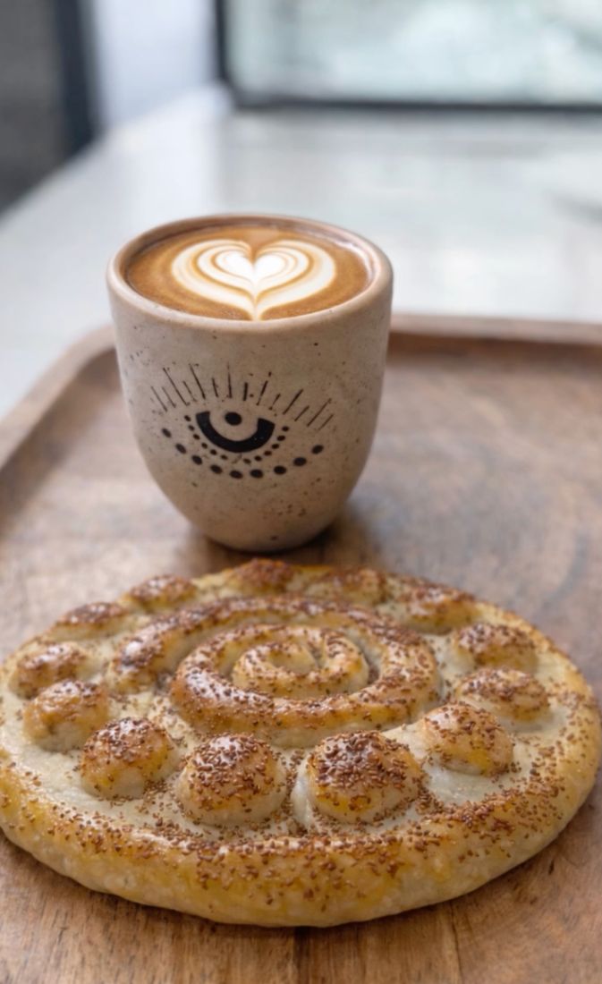 Spiral barbari-style Persian bread with a heart latte in an eye cup